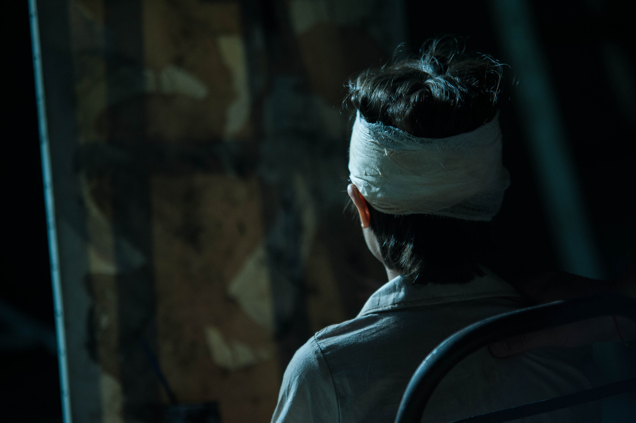 Bandaged performer facing a reflection in a Kintsugi scene