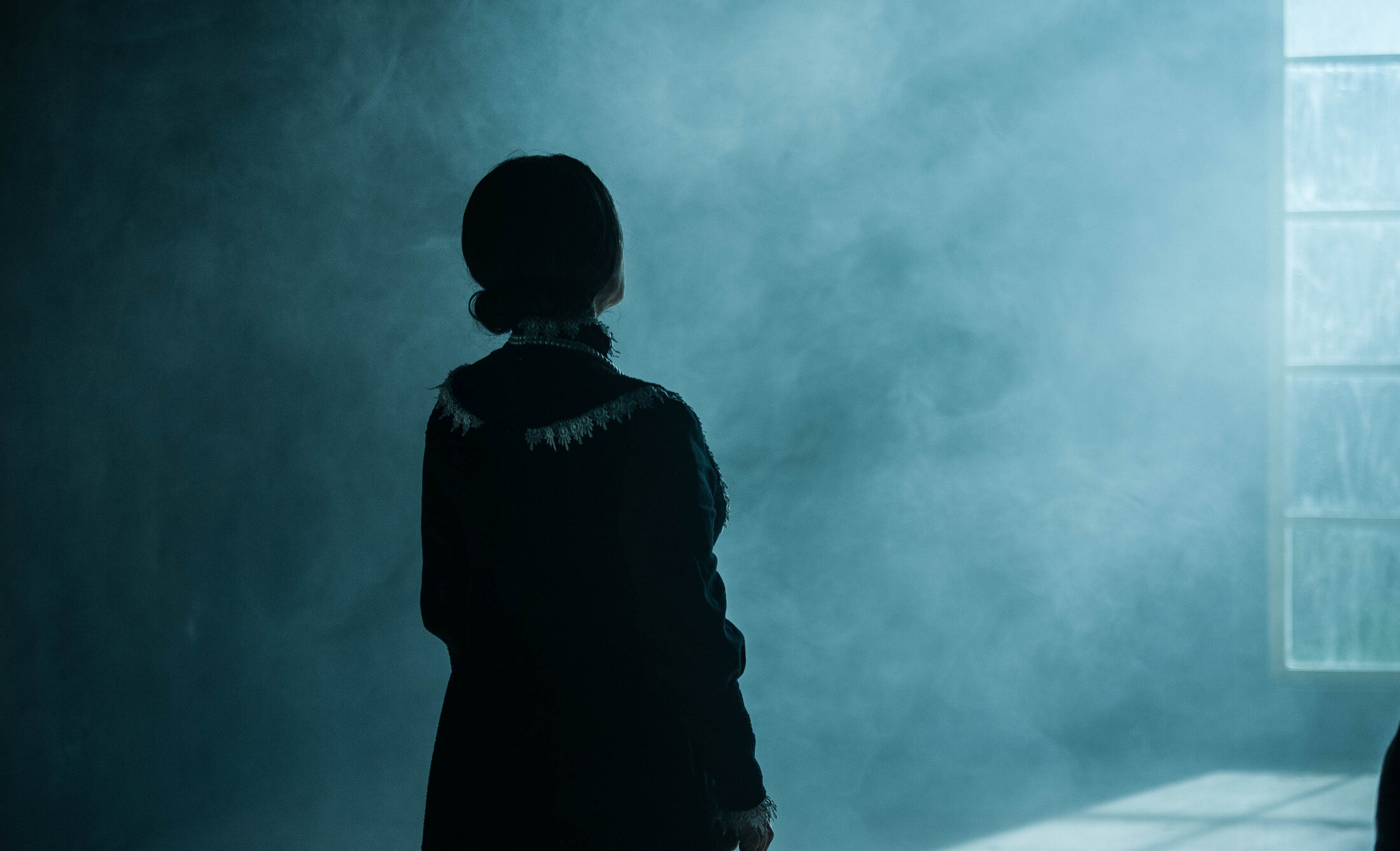 Performer seen in silhouette through smoke on the Kintsugi set